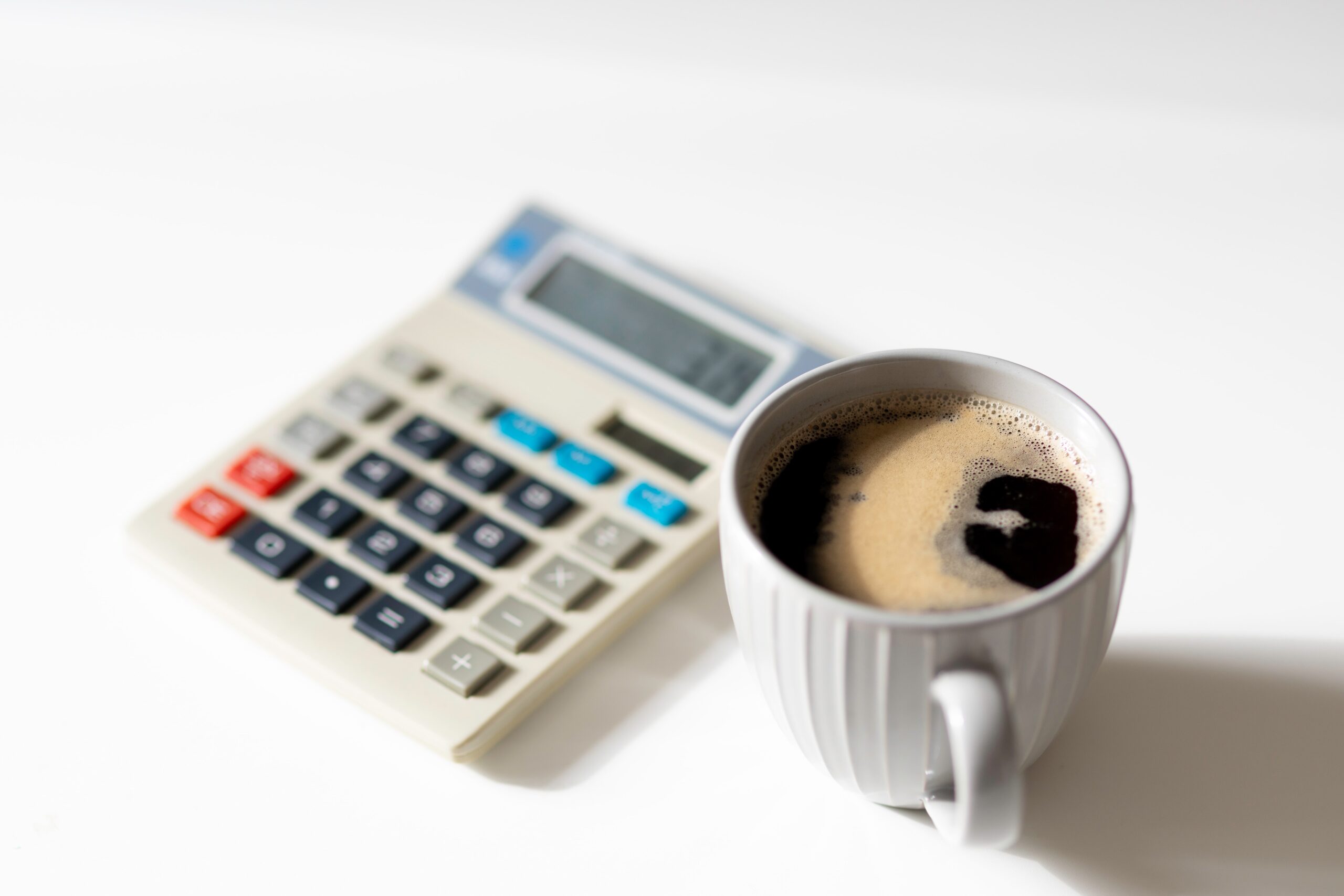 calculator on table beside coffee